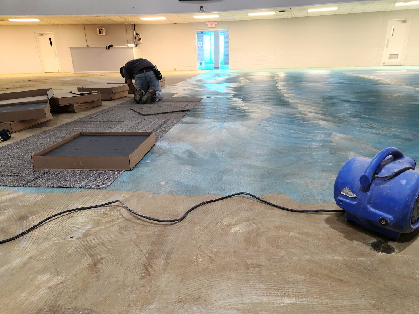 Centrifugal air mover providing structural drying during carpet tile installation on moisture-mitigated slab